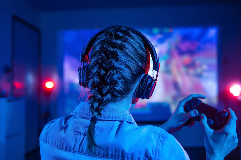 Image showing a woman gamer playing on a projected screen. 