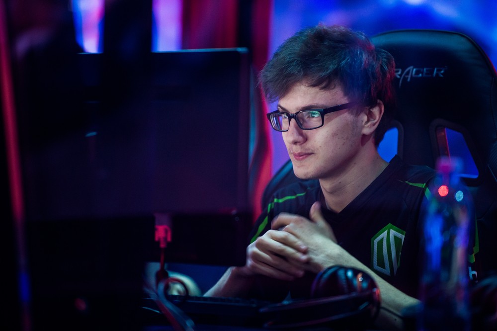 Young white guy sitting in a gaming chair looking at the computer.